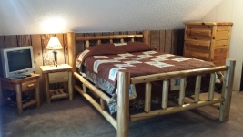 Guest bedroom on upper level. Has queen log bed and twin bed.